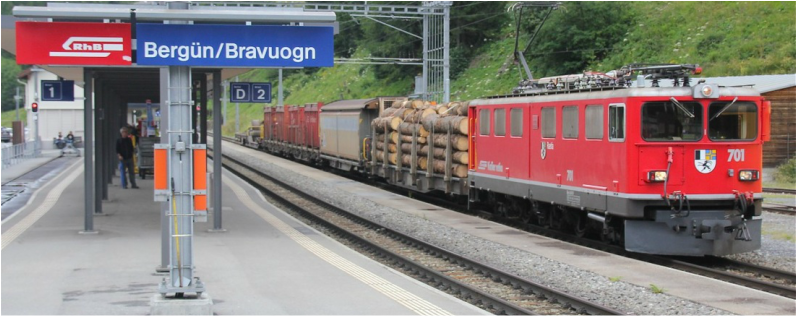 A Swiss RhB freight train waits on a siding at Bergün for the Glacier Express to pass 